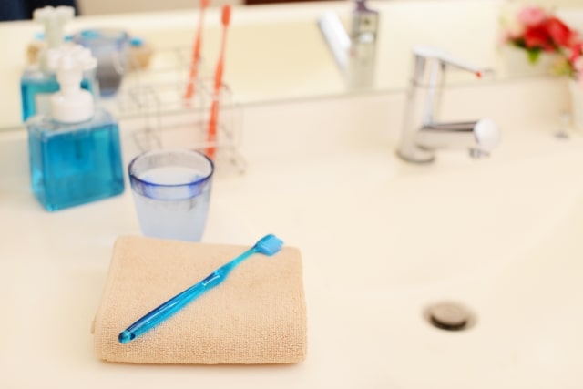 洗面台に置かれた歯ブラシとタオル